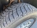 Close-up of a rugged tire with a detailed tread pattern mounted on a shiny wheel from a 2013 Chevrolet Silverado 1500