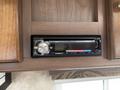 A dual car stereo system with a digital display and various buttons and slots for media input mounted on a wooden surface