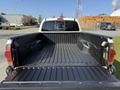 A 2015 Toyota Tacoma truck bed with a black liner and no cargo present, showing the side walls and tailgate in an open position