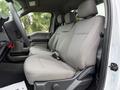 Interior of a 2022 Ford F600 showing two gray fabric seats with headrests and seatbelt buckles placed inside the cabin