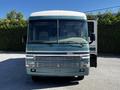 A blue and white 2000 Ford Motorhome with large windows and a prominent front grille showcasing its logo