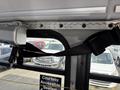 A seatbelt attached to the interior of a 2018 Chevrolet Express with distinct metal brackets and a sign indicating accessible seating