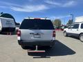 A white 2013 Ford Expedition viewed from the rear with a chrome bumper and a visible tow hitch