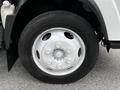 Close-up of a silver wheel from a 2018 Isuzu NPR with visible lug nuts and a black tire with tread pattern