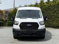 A white 2022 Ford Transit van is shown from the front featuring a bold black grille and large headlights with side mirrors visible