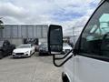 A 2020 Chevrolet Express van with a side mirror visible in the foreground