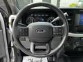 Steering wheel of a 2024 Ford F-550 with buttons for various controls and a Ford logo in the center