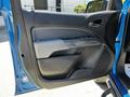 The interior door panel of a 2021 Chevrolet Colorado featuring a combination of gray and black materials with window controls and a smooth armrest