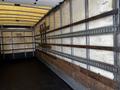 Interior of a 2006 Hino 268 truck with wooden slats on the walls and a black rubber floor