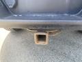 A rusted trailer hitch attached to the rear of a 2017 Ford F-150