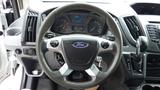 Steering wheel of a 2018 Ford Transit featuring the Ford emblem and various control buttons on the spokes