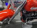 A 2024 Harley Davidson Fat Boy with a shiny red body and chrome accents showcasing its powerful engine and distinctive design features