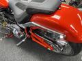 A 2024 Harley Davidson Fat Boy with a shiny red exterior and chrome accents highlighting its muscular build and prominent features