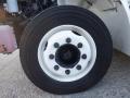 A close-up of a white wheel rim with multiple bolts and a black tire mounted on a 2014 International Durastar vehicle