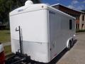 A white 2004 Royal 18 Foot office trailer with a metal diamond plate at the bottom and a hitch at the back