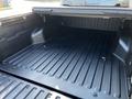 The image shows the bed of a 2021 Toyota Tacoma with a textured black liner and no visible cargo or items inside