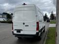 A 2021 Mercedes-Benz Sprinter van viewed from the rear showcasing its large white cargo area and distinctive Mercedes-Benz emblem