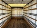 The interior of a 2017 Hino 155 truck with wooden floors and metal straps along the walls for securing cargo