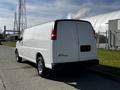 A white 2015 Chevrolet Express van parked with its back facing the viewer showcasing its smooth body and chrome wheels