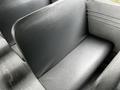 A close-up view of a black vinyl bench seat from a 2015 Spartan School Bus showing a smooth surface and minimal wear