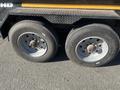 Close-up of the wheels and tires of a 2024 Southland 18 Foot Dump Trailer with a textured surface visible on the trailer body