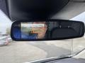 A rearview mirror displaying a backup camera image with a warning symbol in the center showing a vehicle behind the 2017 Ford Transit