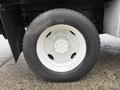 Close-up of a white wheel with a five-bolt pattern mounted on a black tire designed for a 2013 Ford F-650