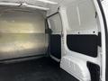 Interior view of a 2020 Nissan NV200 cargo van showing a spacious, empty cargo area with a metal wall and some black paneling on the sides