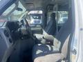 Interior view of a 2009 Ford Econoline featuring two gray upholstered seats a steering wheel and a divider partition behind the front seats