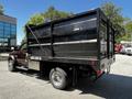 A 2015 RAM 5500 truck with a black dump bed featuring a rear tailgate and dual rear wheels
