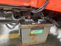A rusted battery mounted on a Kubota F3680 with visible wires and connectors