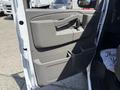 A 2017 GMC Savana van's interior side door panel featuring a handle and storage compartment