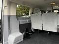 Interior view of a 2018 Ford Transit showing vacant rear seating area with gray fabric upholstery and a flat floor space