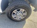 A close-up of a black rim with five spokes and a silver center cap mounted on a rugged tire with raised lettering