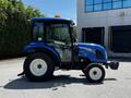 A blue 2018 New Holland Boomer 45 tractor with enclosed cab and large rear tires, positioned sideways and showcasing its distinct design and features