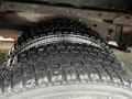 A close-up view of a tire with deep treads, part of a 2012 Ford Econoline, showcasing its durable performance design