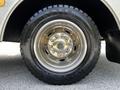 Close-up of a shiny wheel on a 2009 Ford F-550 featuring a multi-spoke chrome rim and a robust black tire labeled as "AUSTONE" with a tread pattern visible