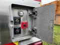 A control panel on a fire truck featuring buttons for right rear stabilizer and ladder rack with a hinged metal cover