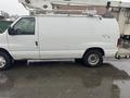 2008 Ford Econoline van in white color with a sliding side door and a utility ladder rack on top