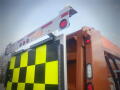 A 2016 International WorkStar 7500 truck with a yellow and black checkerboard patterned back and reflective lights on top