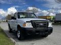A silver 2010 Ford Ranger with a black grille and chrome wheels parked on a paved surface