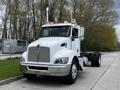 A 2014 Kenworth T370 truck with a white body, chrome grille, and dual exhaust stacks parked on a paved surface