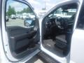 Interior view of a 2022 Ford F-150 showing the driver's side door and dashboard with a black seating area and modern controls