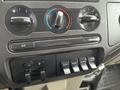 Close-up of the climate control panel and auxiliary switches in a 2010 Ford F-250 SD featuring dials for temperature and fan speed