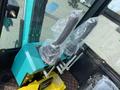 2024 AGT Industrial QH13R Mini Excavator controls featuring two joystick handles wrapped in plastic and a yellow control box