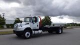 2015 International DuraStar 4300 truck in white with a flatbed design and red accents positioned at the front