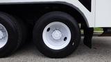 A close-up of a white wheel with a silver rim on a 2012 International 7400 truck featuring a large black tire