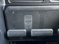 A wireless charging pad with a textured surface labeled with a wireless charger symbol inside a 2022 RAM 3500 vehicle