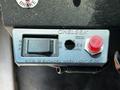Close-up of a control panel featuring a Chelsea switch labeled for power take-off engagement and a red button along with a label indicating the switch states