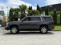 A 2017 Chevrolet Tahoe is parked sideways with a gray exterior and chrome wheels